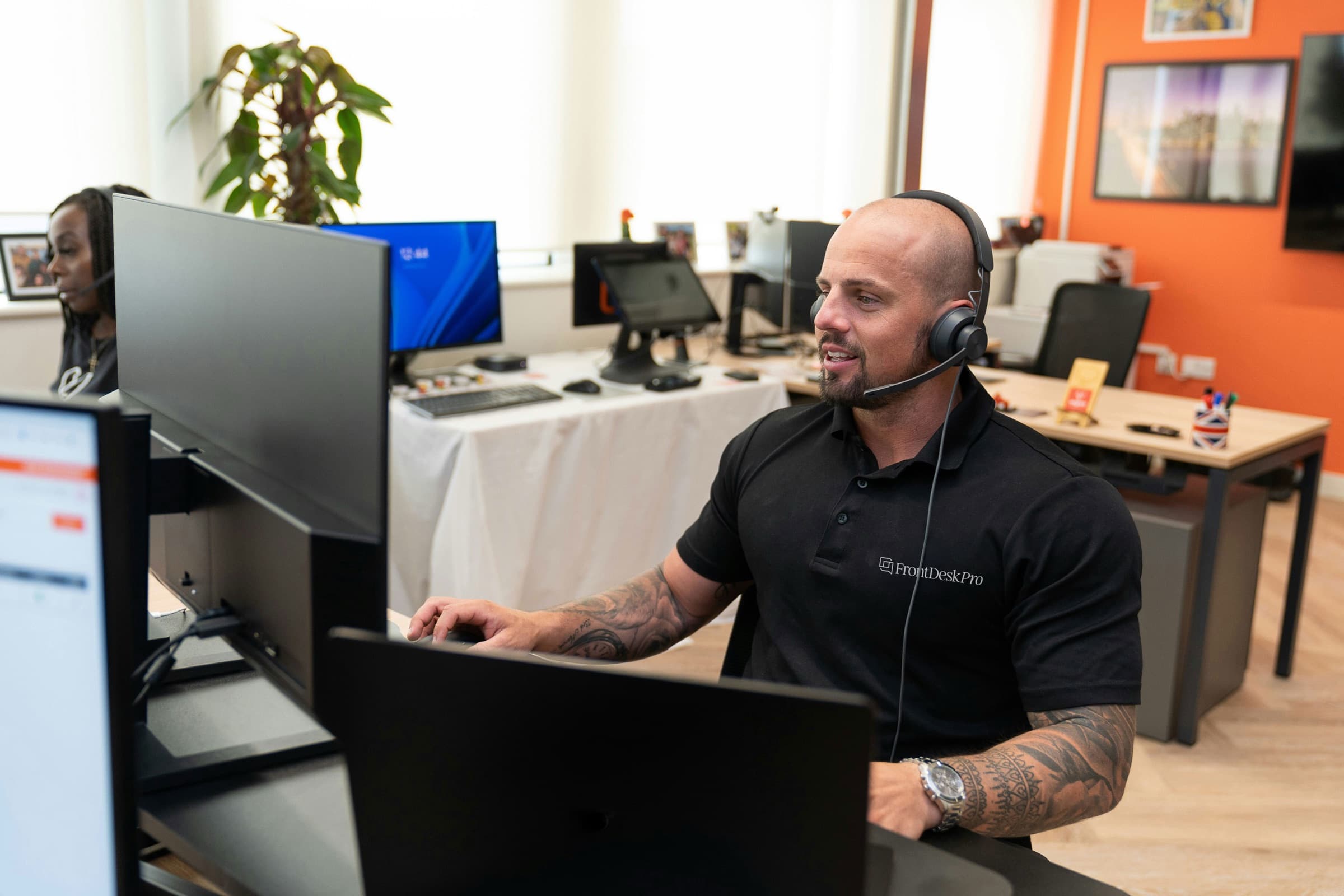 A FrontDeskPro team member wearing a headset at a CSR workstation