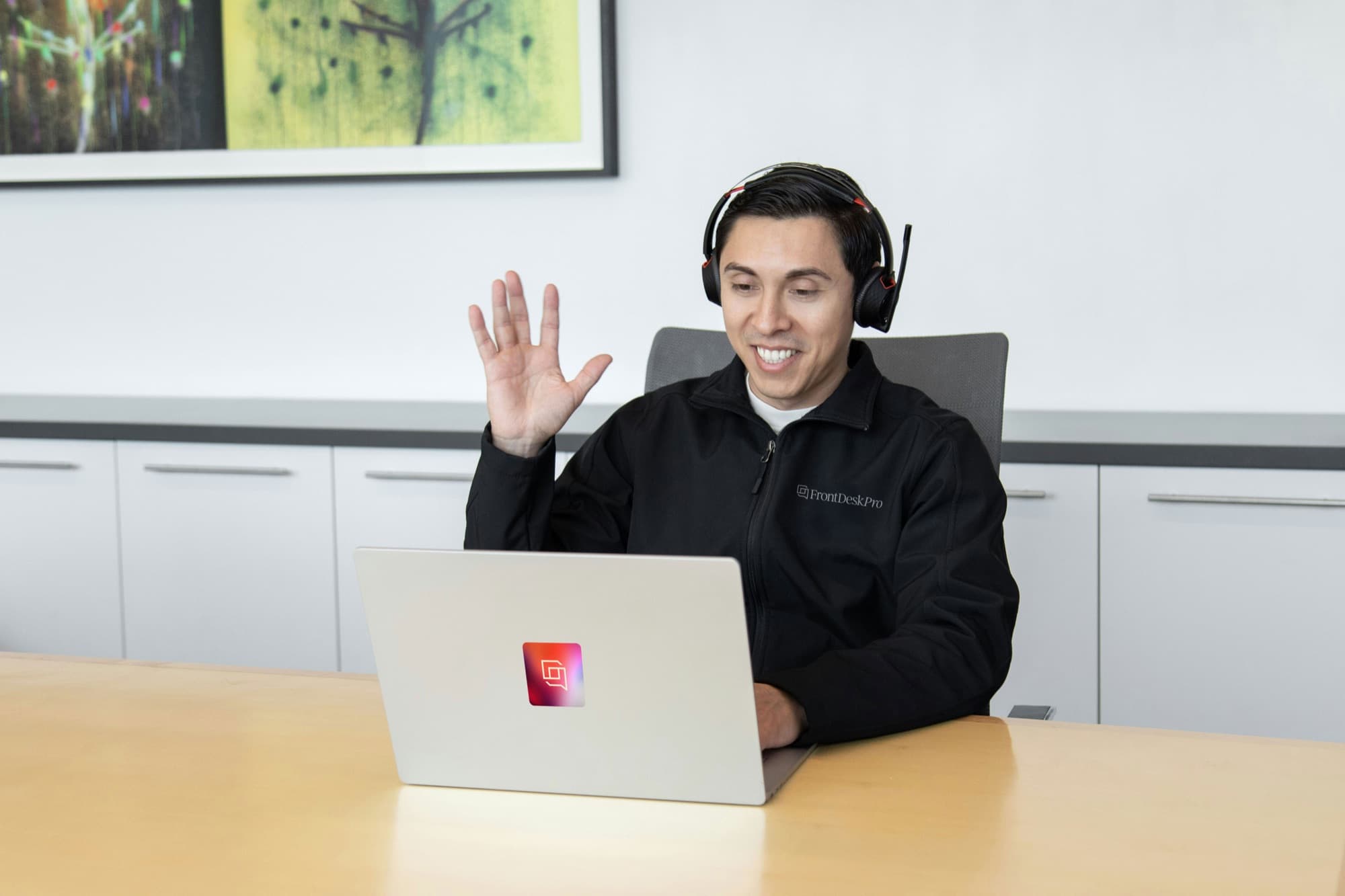 A FrontDeskPro team member waving at the start of a video demo call